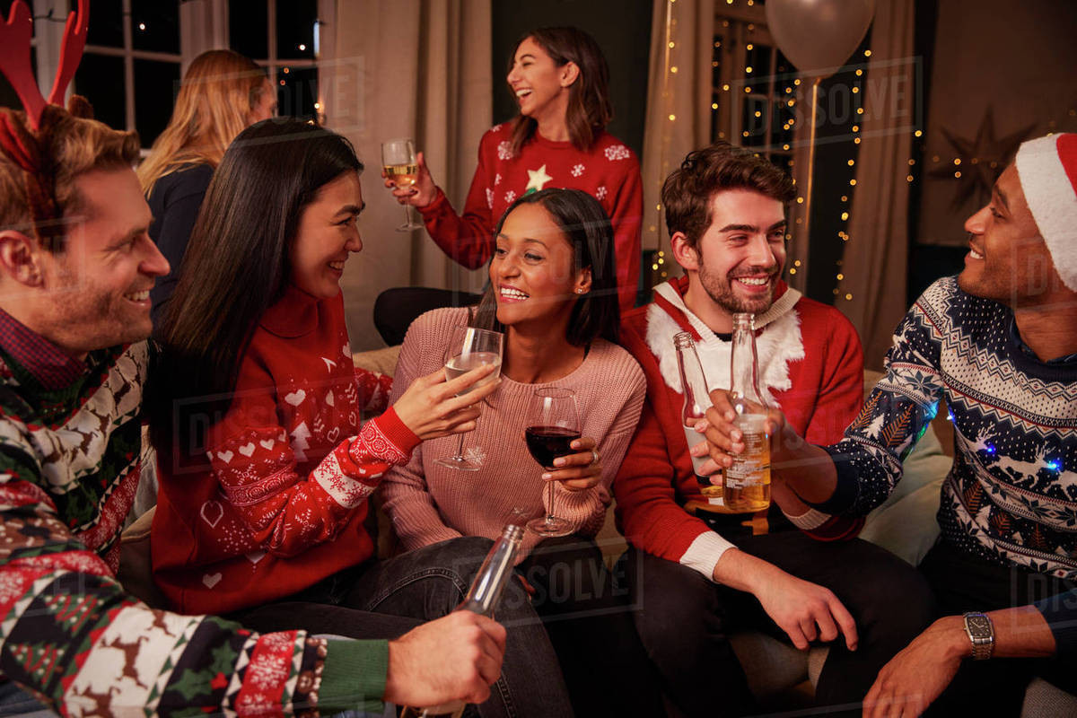 Friends Christmas Party Ideas
 Friends in festive jumpers celebrate at christmas party